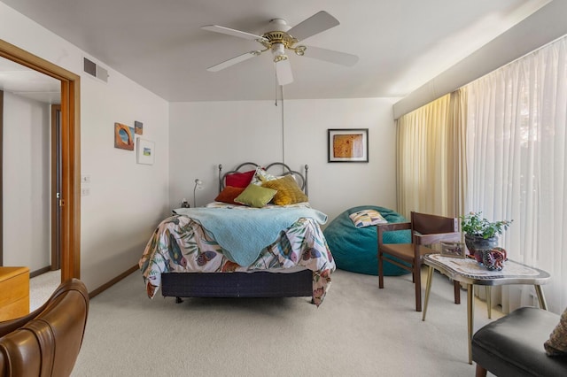 bedroom featuring multiple windows, light colored carpet, and ceiling fan