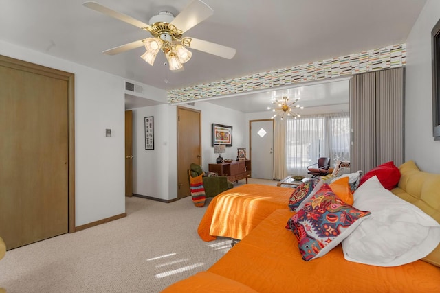 carpeted bedroom featuring ceiling fan with notable chandelier