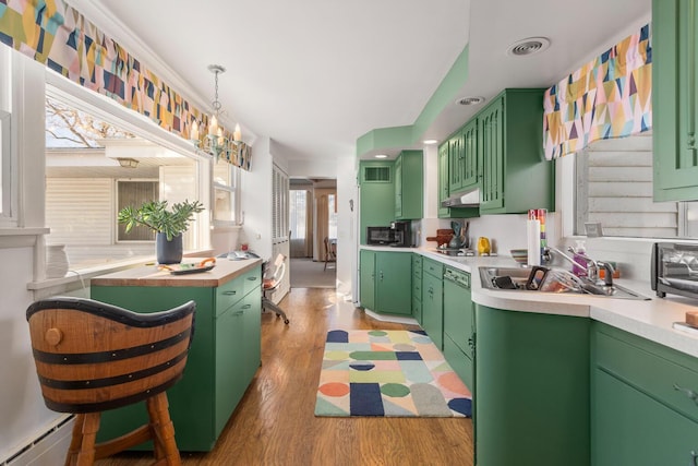 kitchen with sink, green cabinetry, baseboard heating, dishwasher, and light hardwood / wood-style floors