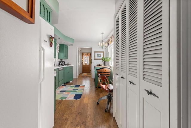 hallway with dark hardwood / wood-style flooring and an inviting chandelier