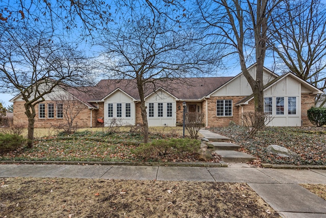 view of front facade featuring brick siding and roof with shingles