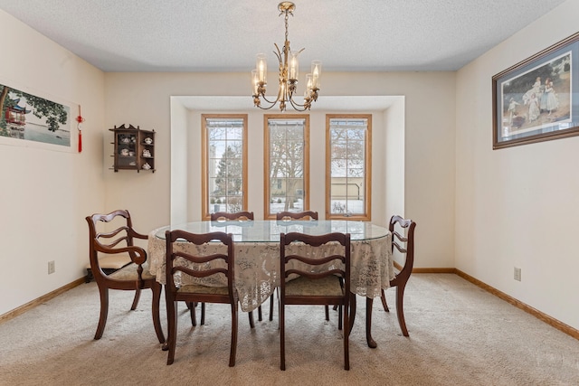 dining room with a chandelier, light colored carpet, a textured ceiling, and baseboards