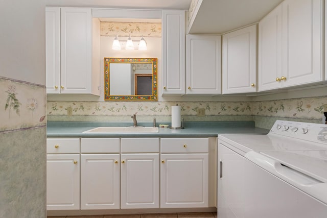 clothes washing area with washing machine and dryer, cabinet space, and a sink