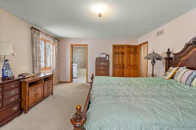 carpeted bedroom with ensuite bath and a textured ceiling