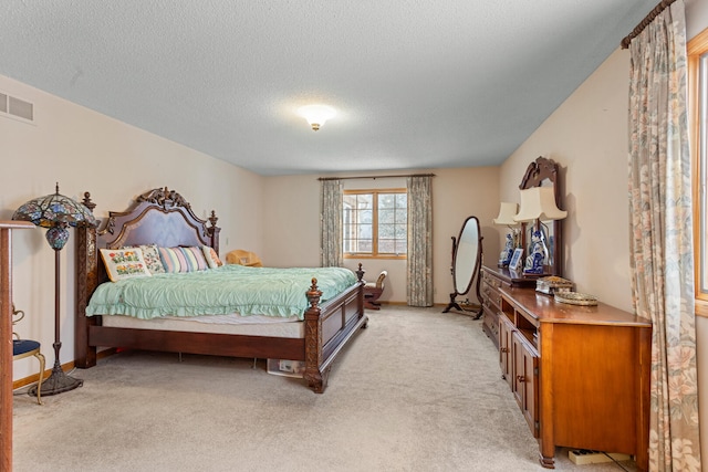 bedroom with light colored carpet and a textured ceiling