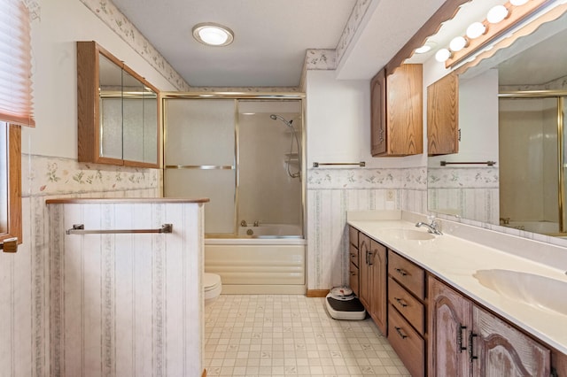 full bathroom with toilet, vanity, and shower / bath combination with glass door