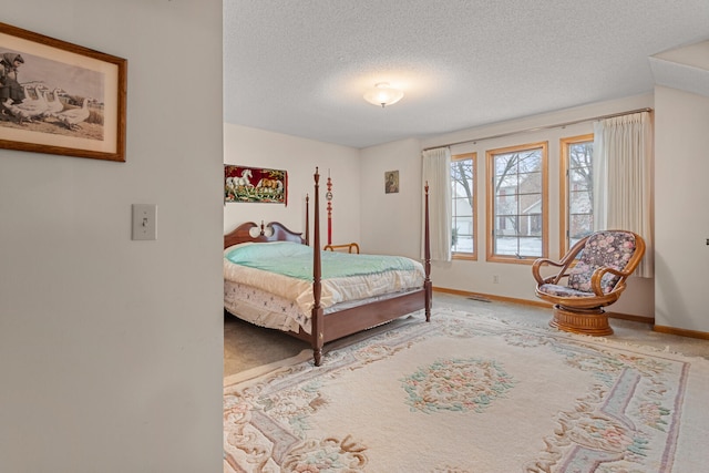 bedroom featuring a textured ceiling, carpet flooring, and baseboards