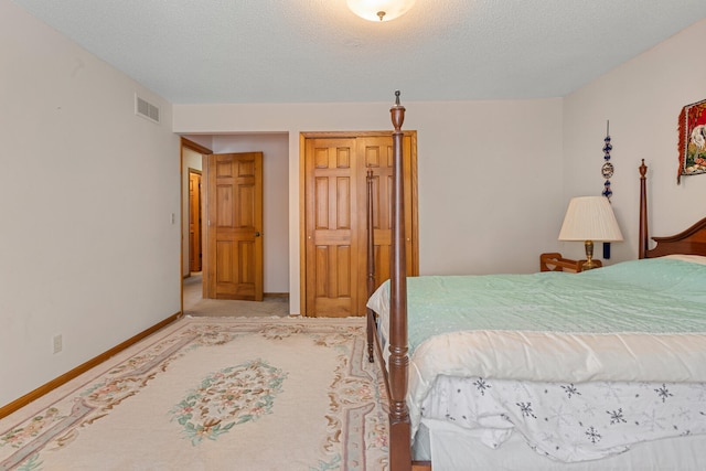 bedroom featuring light colored carpet, visible vents, baseboards, and a textured ceiling