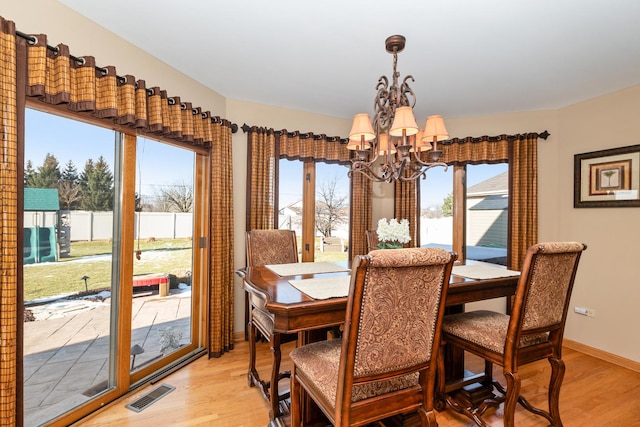 dining room featuring a chandelier, light hardwood / wood-style floors, and plenty of natural light