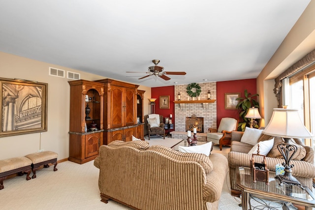 carpeted living room with ceiling fan and a fireplace