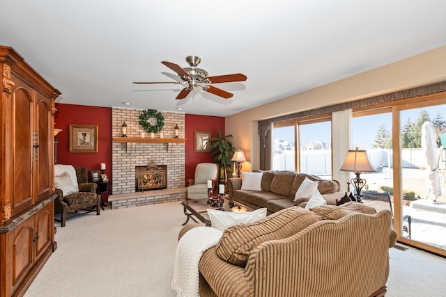 carpeted living room featuring a brick fireplace and ceiling fan