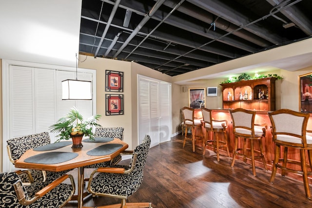 dining space with bar area and dark hardwood / wood-style floors