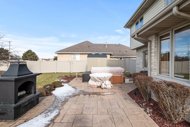 view of patio featuring an outdoor fireplace and a hot tub