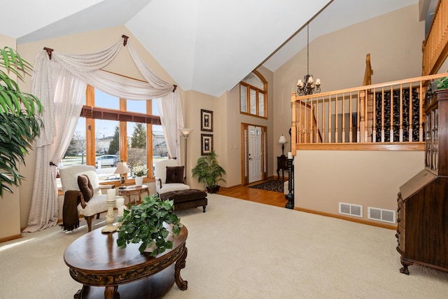 sitting room with a notable chandelier, vaulted ceiling, and light carpet