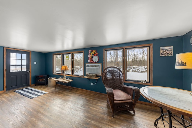 interior space with an AC wall unit and hardwood / wood-style floors