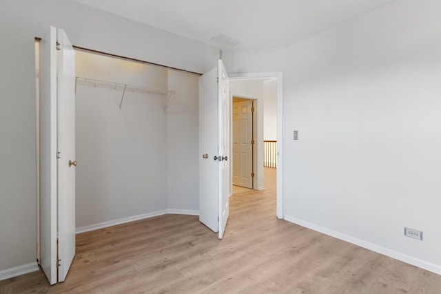 unfurnished bedroom with a closet and light wood-type flooring