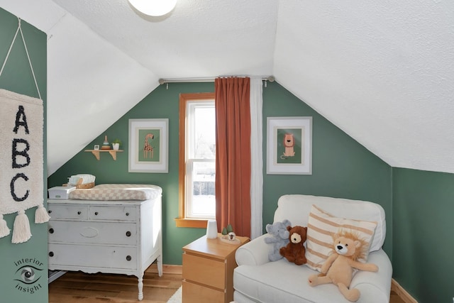 sitting room featuring hardwood / wood-style flooring, a textured ceiling, and lofted ceiling