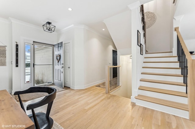 foyer entrance with light hardwood / wood-style floors and crown molding