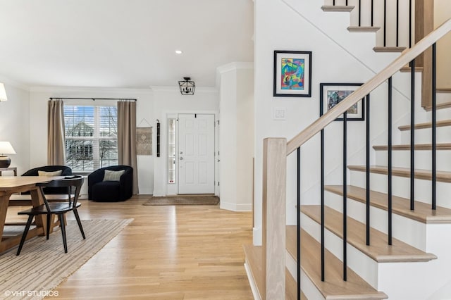 foyer entrance featuring light wood-type flooring and ornamental molding