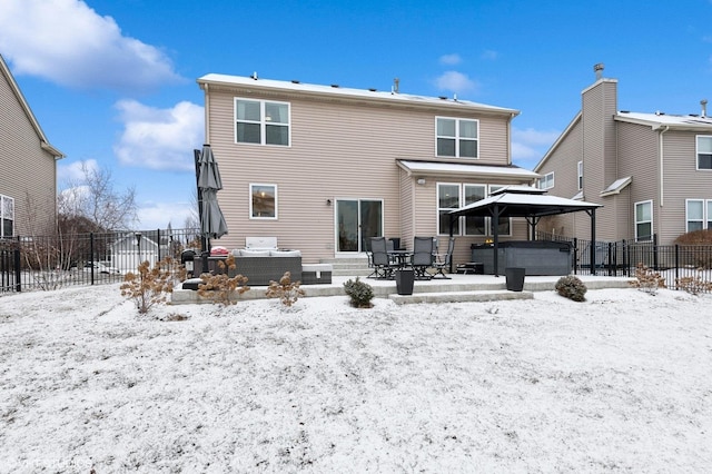 snow covered house with a gazebo and a hot tub