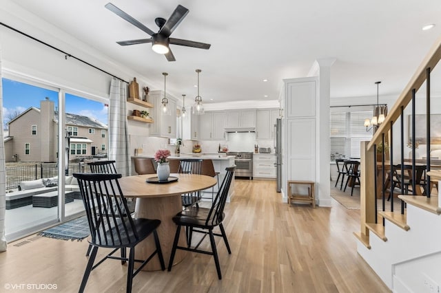 dining area with light hardwood / wood-style floors, sink, ornamental molding, and ceiling fan with notable chandelier