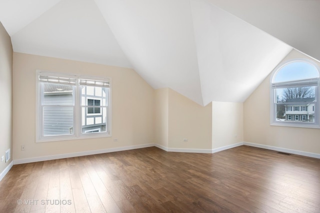 bonus room with lofted ceiling, dark wood-type flooring, and a wealth of natural light