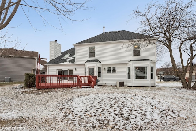 snow covered back of property featuring cooling unit and a deck