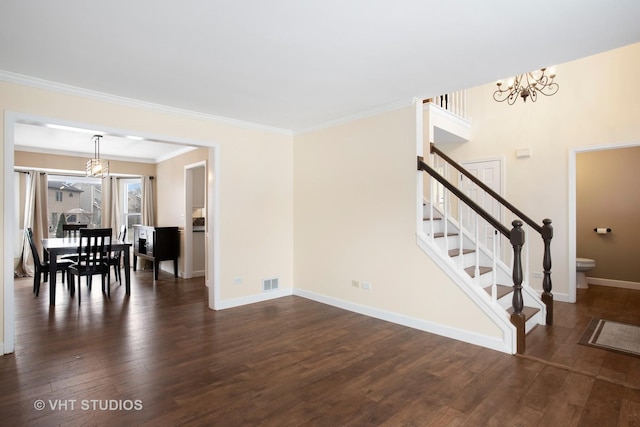 living room with ornamental molding, dark hardwood / wood-style floors, and an inviting chandelier