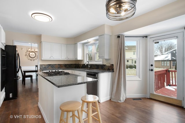 kitchen with stainless steel appliances, dark hardwood / wood-style flooring, a center island, and white cabinets