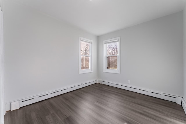 unfurnished room with dark wood-type flooring and baseboard heating