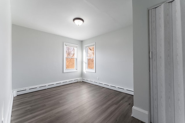 spare room with dark hardwood / wood-style flooring and a baseboard radiator