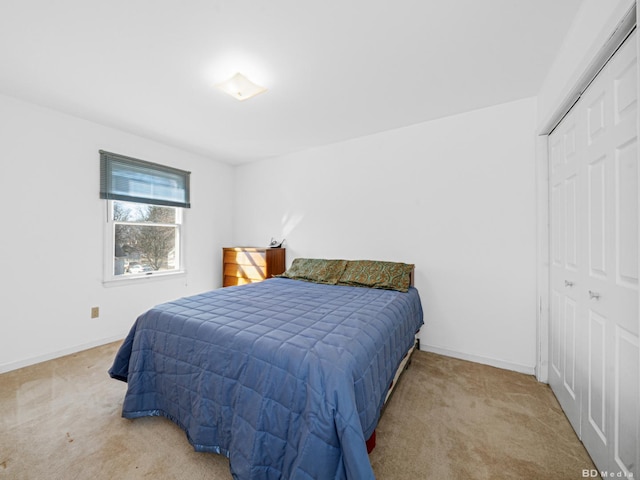 bedroom with a closet, baseboards, and carpet