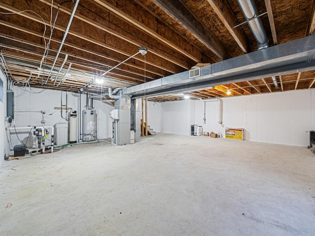 unfinished basement featuring heating unit, visible vents, gas water heater, and electric panel