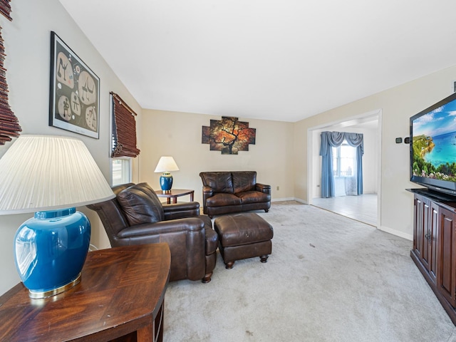 carpeted living room featuring baseboards