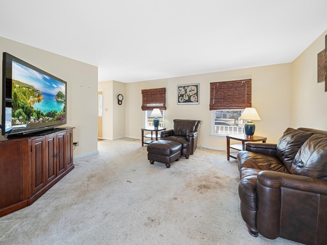 living area featuring light colored carpet and baseboards