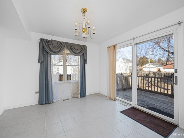 unfurnished dining area featuring plenty of natural light, baseboards, visible vents, and a chandelier