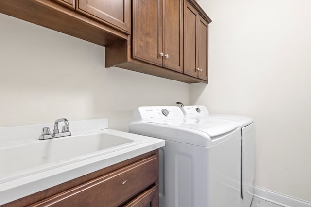 laundry area featuring cabinets, washer and dryer, sink, and light tile patterned floors