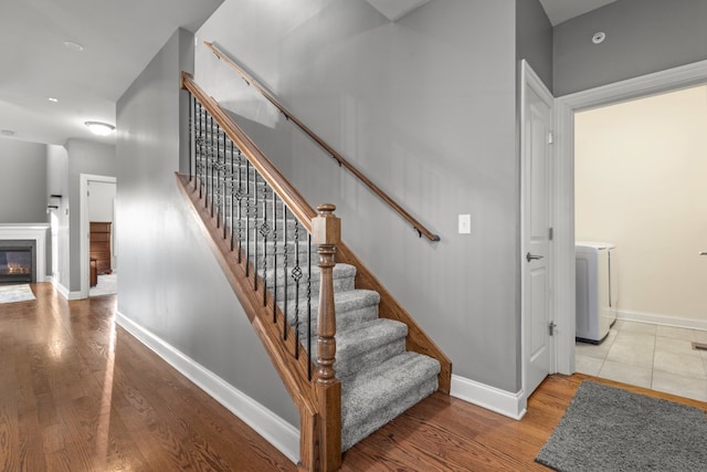 stairway with washer / clothes dryer and hardwood / wood-style floors