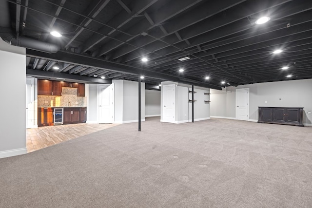 basement featuring bar area, beverage cooler, and carpet floors