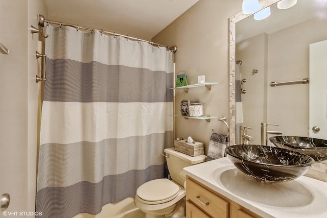 bathroom with toilet, vanity, and walk in shower