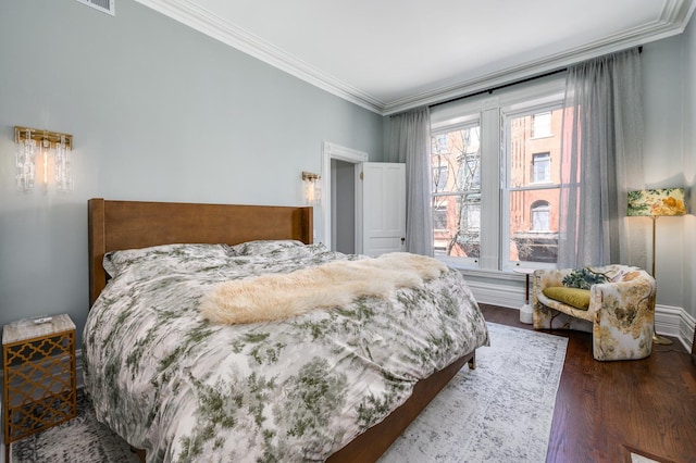 bedroom with dark hardwood / wood-style flooring and ornamental molding