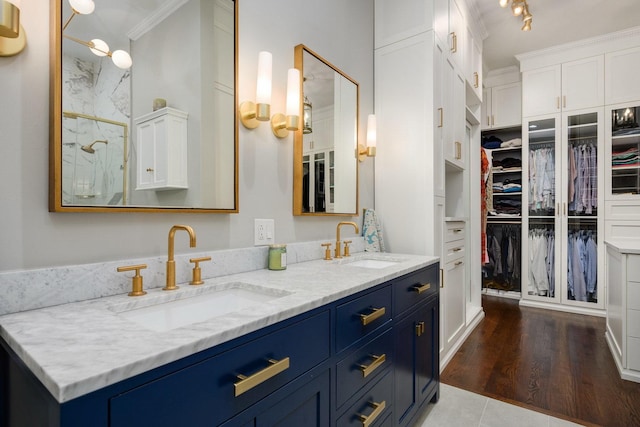 bathroom with wood-type flooring, vanity, and crown molding