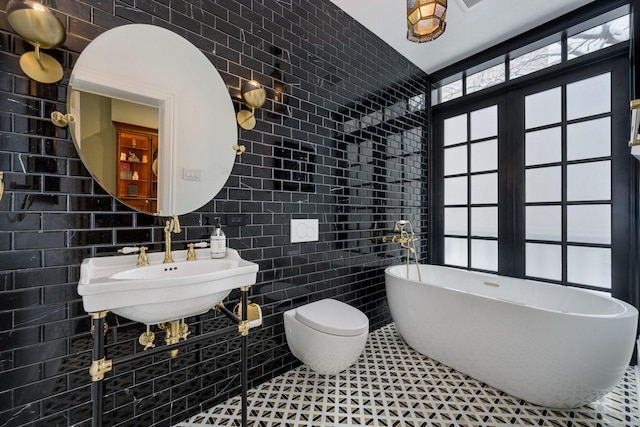 bathroom with a bathtub, tile walls, toilet, and tile patterned flooring