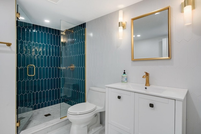 bathroom featuring toilet, vanity, and a shower with door