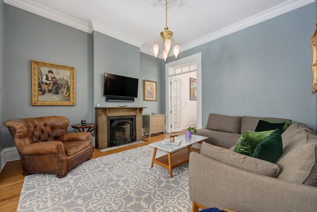 living room featuring hardwood / wood-style floors, ornamental molding, and a chandelier