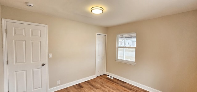 unfurnished bedroom with a closet and hardwood / wood-style floors