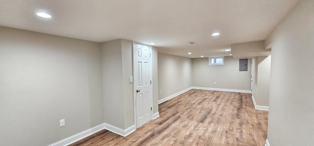 basement with electric panel and hardwood / wood-style floors