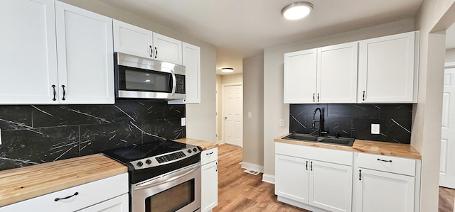 kitchen with white cabinets, appliances with stainless steel finishes, and sink