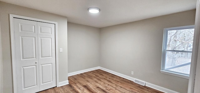 empty room featuring plenty of natural light and hardwood / wood-style floors