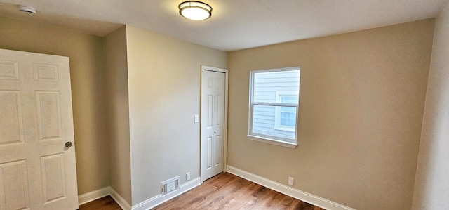 unfurnished bedroom with a closet and hardwood / wood-style flooring